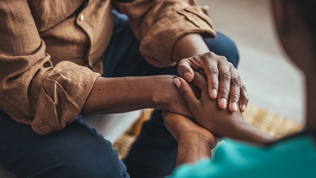 Close-up of two people, male and female, holding hands