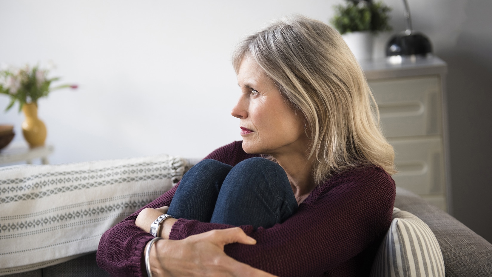 Worrying Caucasian woman hugging legs
