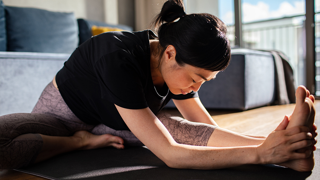 Woman bending over leg and holding on to foot