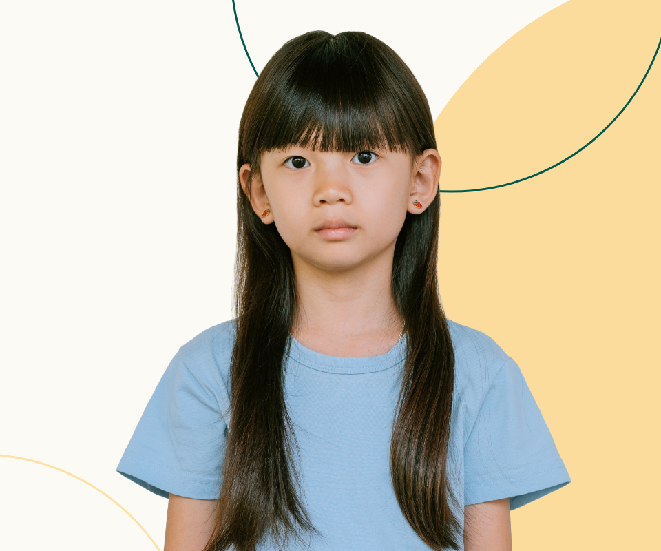 Young asian girl with long brown hair wearing a blue t-shirt