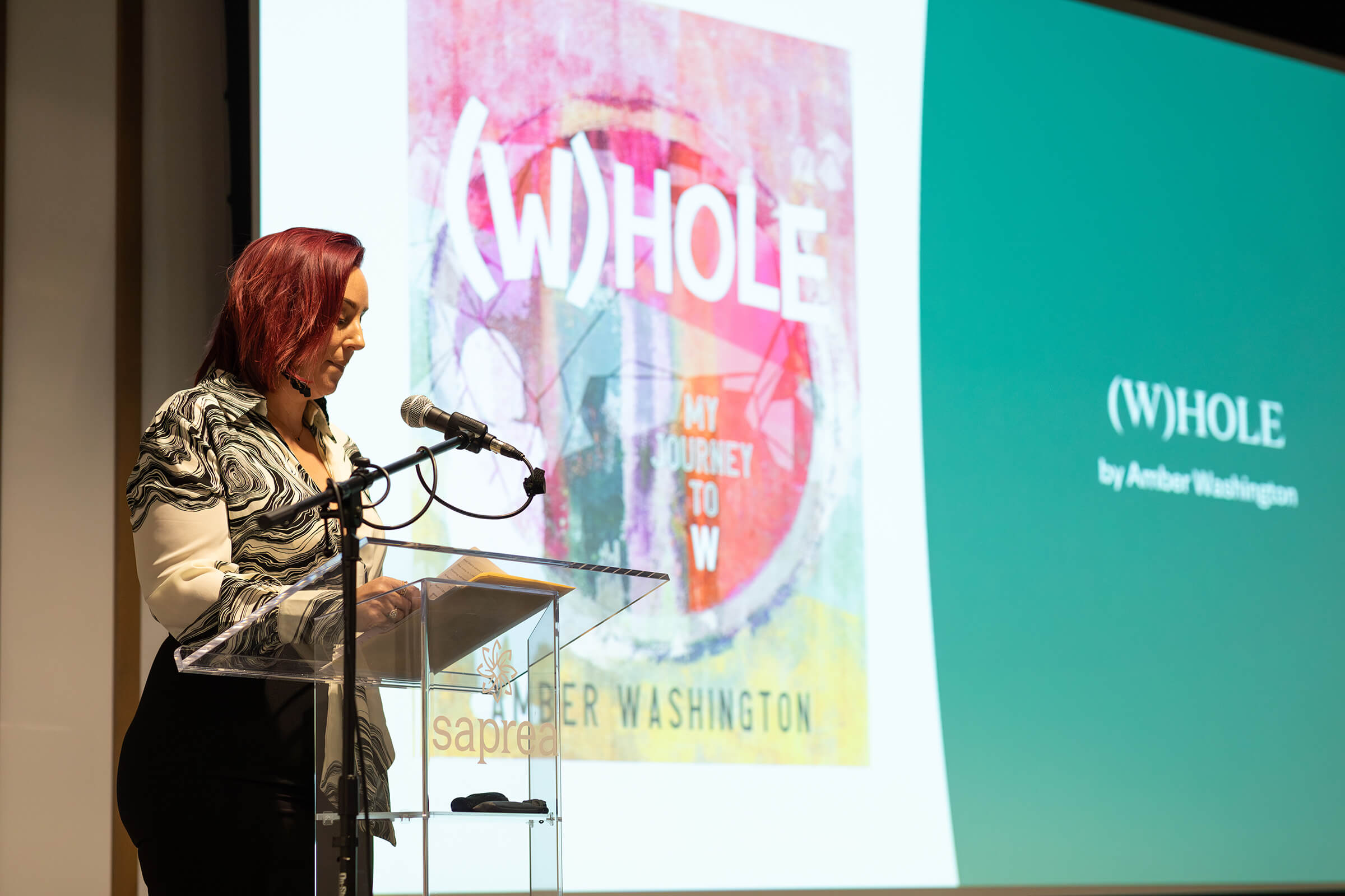Women standing clear podium with a projected image behind her.