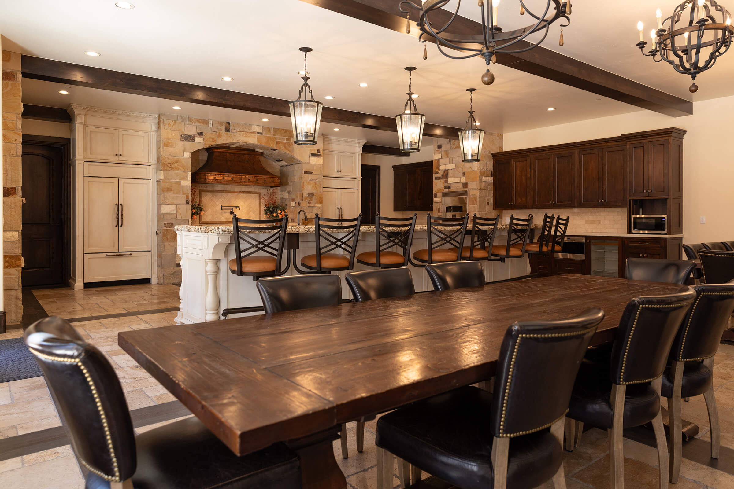 Kitchen with open range, bar seating, and a large table with chairs.
