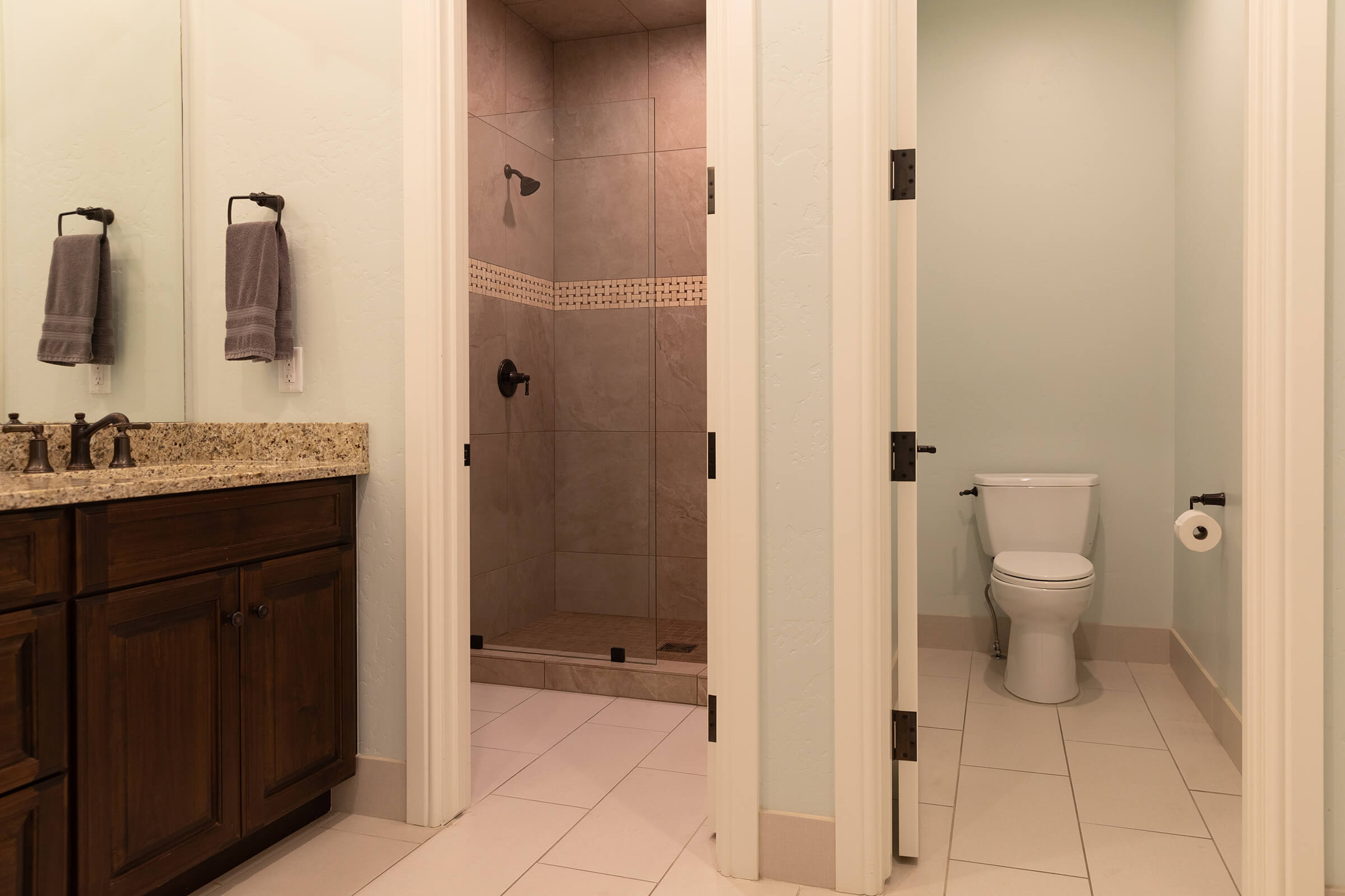 Bathroom showing an enclosed toilet room, and enclosed shower room.