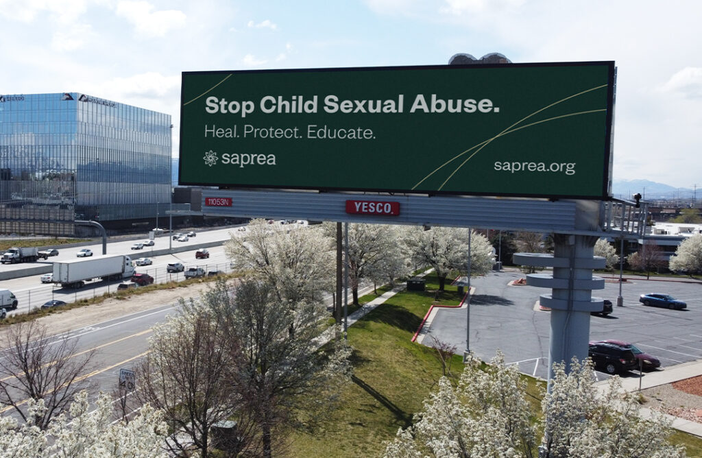 Green billboard pictured over a busy highway.