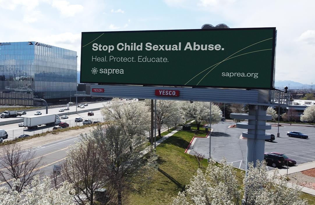 Green billboard pictured over a busy highway.